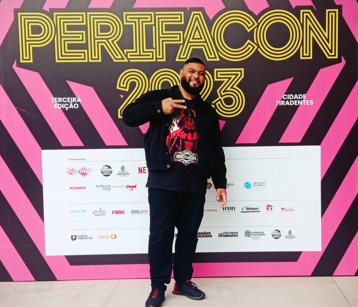 Rafael Braga posa na frente do painel da PerifaCon 2023