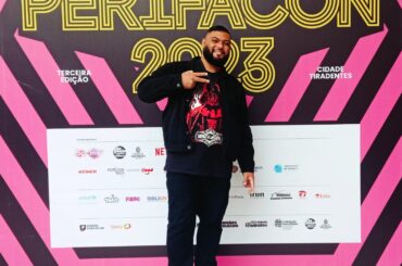 Rafael Braga posa na frente do painel da PerifaCon 2023