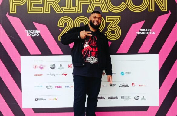 Rafael Braga posa na frente do painel da PerifaCon 2023