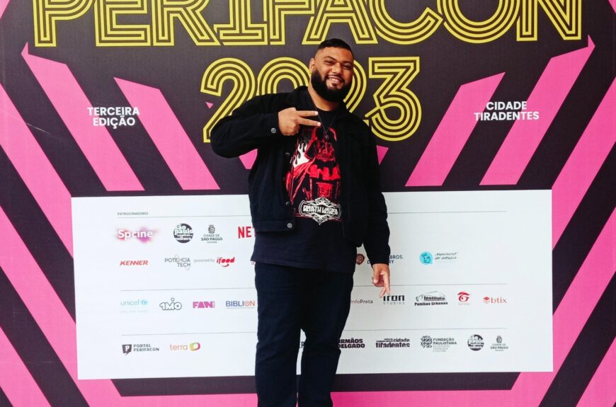 Rafael Braga posa na frente do painel da PerifaCon 2023